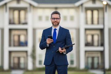 Real estate agent business man in suit hold holder clipboards and talking on phone. Businessman....