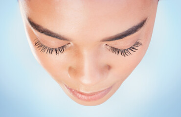 Above, beauty and woman face with closeup, studio and natural for skincare on blue background....