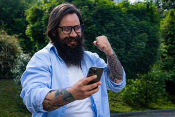 portrait of a man who is happy with success looking at the phone