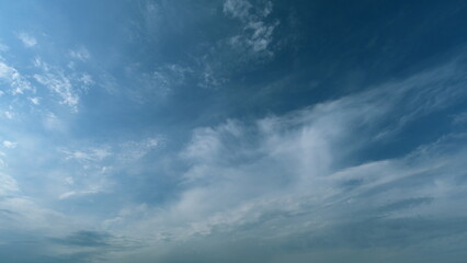 Flying moving white clouds in a blue sky. Blue sky background with many layers tiny clouds....