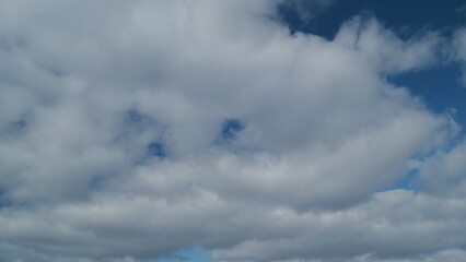 Clouds in blue sky slowly move and change shape. Changing stratocumulus cloudscape. Timelapse.