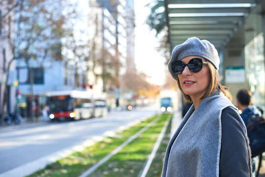 Chic woman in urban setting with tram in the background