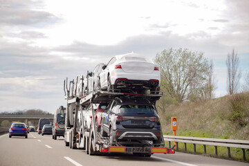 Carrying and transporting new cars on the highway using a truck. Automotive industry.
