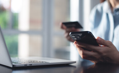 Young woman using mobile smart phone and credit card for digital banking via mobile banking app, internet payment and online shopping, financial technology, global business, e-transaction