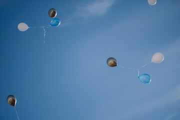 A bunch of multicolored balloons with helium on a blue sky background