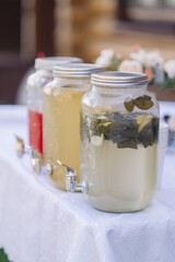 water from jug pouring into glass on wooden table outdoors
