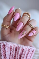Pink stiletto nails with gold rings.