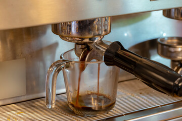 Coffee flowing from Portafilters being brewed in an espresso machine.