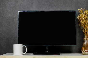 black screen tv with white coffee mug , white porcelain mug mock up on wood table with gypsophila...