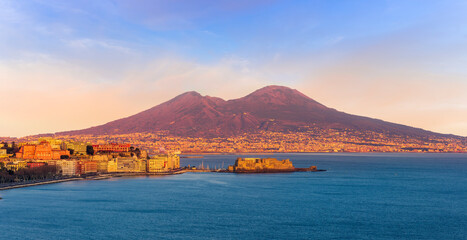 beautiful panorama of volcano Vesuveus from Naples with blue water of sea gulf, majectic mountain and amazing cloudy sunset sky on background