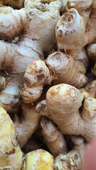 Close up pile of tasty fresh ginger sold at the market as a background.