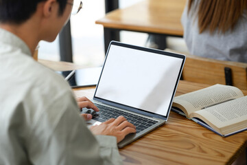 Cropped shot of smart university student doing research, using laptop in a library