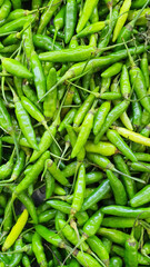 Close up pile of fresh green chilli placed together in local market as a background.	