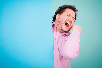 Business solutions. Anger, joy and aggression. Fat man posing on a blue background.