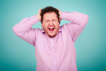 Business solutions. Anger, joy and aggression. Fat man posing on a blue background.