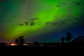 northern lights in outdoor park among cloudy sky in early spring
