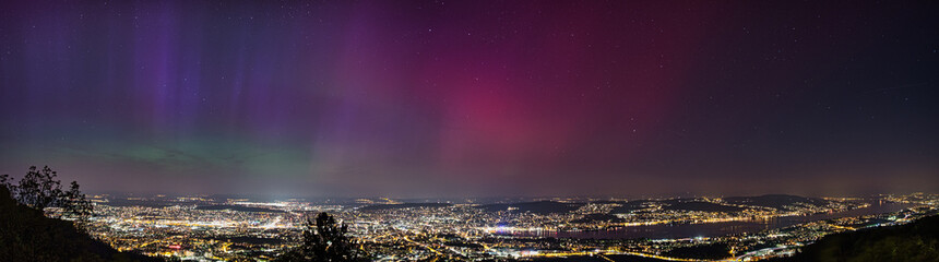 Naklejka premium Large panorama of the city of Zurich in Switzerland from Uetliberg at night with northern lights