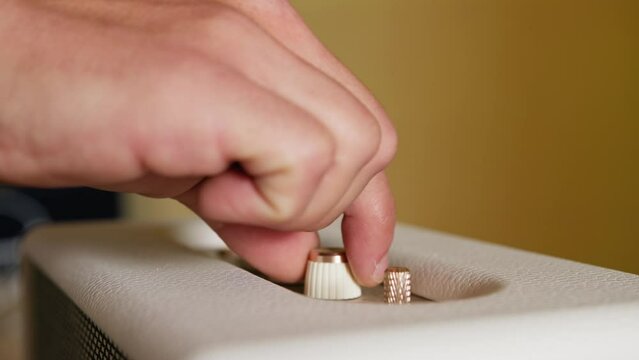 Man's Fingers Touch Switches and Knobs Of A Bluetooth Speaker