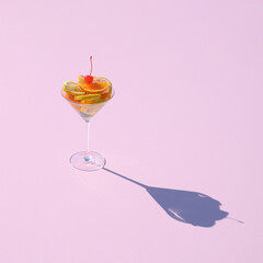 Summer mocktail drink with fruits on a pink background.