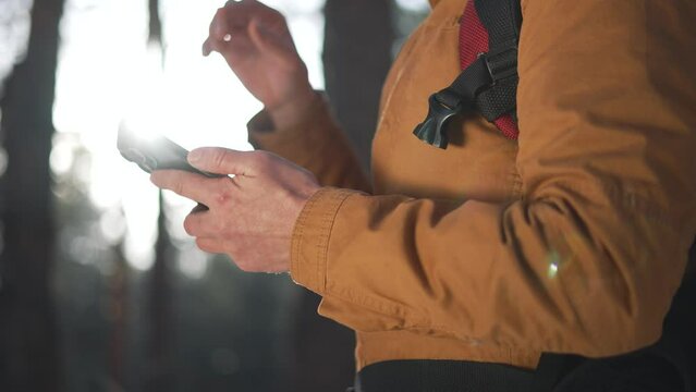tourist equipped with map on his phone moves through forest park. map smartphone is an indispensable tool for exploring tourist routes. tourist travels to forest park guided by digital map his phone.