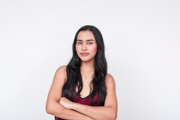 A young Asian woman dressed in a chic maroon dress looking pissed and angry, arms crossed. Isolated on a white background.