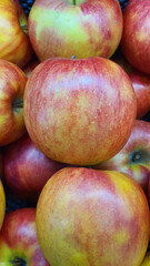 Close up pile of tasty fresh apples sold at the market as a background.
