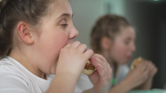 kids sit and celebrate weekend with hamburger feas enjoying every bite. weekend is marked by children laughter and shared burgers. Burgers and weekend mood children enjoy every pleasant moment.