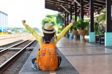 traveler and tourist asia young women wearing backpack holding map, waiting for a train. travel...