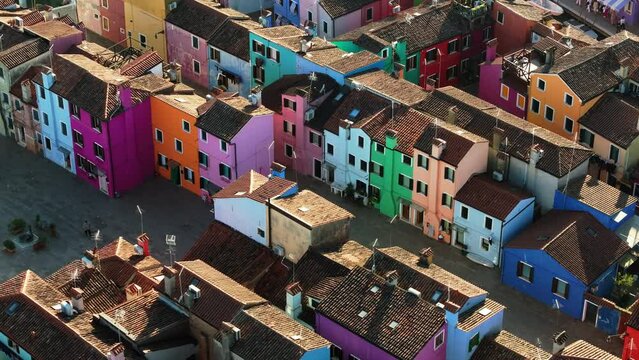 Aerial view of boats on the sides of a canal near the colourful houses of Burano, Italy