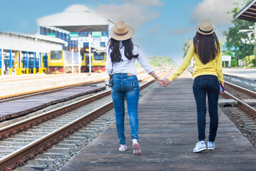 traveler and tourist asia young women wearing backpack holding map, waiting for a train. travel...