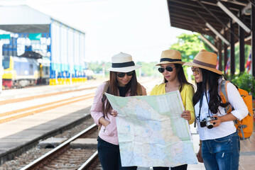 traveler and tourist asia young women wearing backpack holding map, waiting for a train. travel concept.