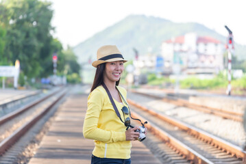 traveler and tourist asia young women wearing backpack holding map, waiting for a train. travel...