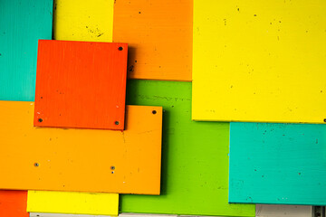 A colorful wall made of different colored squares. The wall is made of wood and has a variety of...