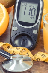 Glucometer, fresh fruits and orange juice. Healthy lifestyle and nutrition containing minerals and...