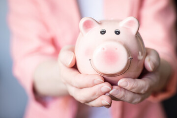 pink piggy bank for saving money on a light background.