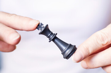 chess piece in female hands on a light background.