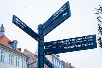 Fototapeta premium Copenhagen, Denmark - April 6, 2024: Directional signpost, arrows pointing to main sights in Copenhagen city center. Tourist guide information post. Travelling in Denmark.