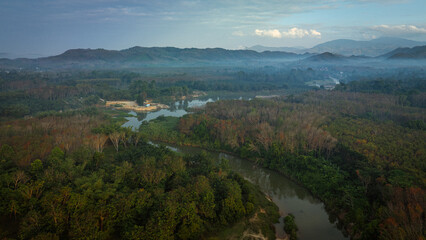 Naklejka premium Aerial view canal river through tropical rainforest mountain morning sunrise nature landscape