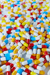 Pharmaceutical industry bunch of various colours white capsule pills on a white background - Medicine healthcare medicament. 3D illustration