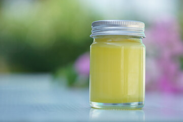 Bottle of homemade Thai herbal yellow ointment, balm.Decorated with  flower. Concept, Thai local wisdom to use fragrant medicinal herbs to make inhaler and massage balm.   