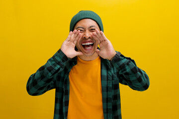 An excited young Asian man, dressed in casual clothes and wearing a beanie hat, is enthusiastically...