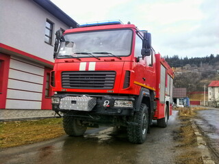 Vintage fire truck parked outside a fire station
