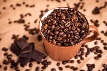 many macro aromatic coffee beans in a cup  on the background.