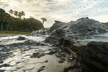 seascape is very beautiful with coral rocks and sea water that looks very soft like cotton at Sawarna Beach, Indonesia. slow shutter speed effect