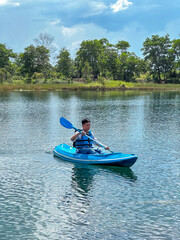 Asian young man using a canoe on Lake Seran in Banjarbaru, South Kalimantan