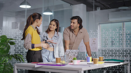 Indian Asian Hindu busy boss lady talk share idea plan use laptop teen girl boy team listen indoor...