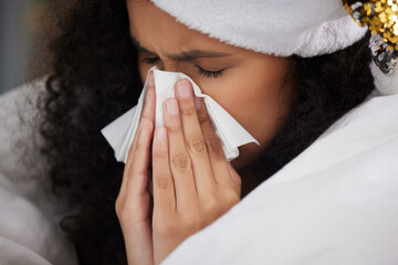 Woman, blanket and sick with tissue on Christmas or blowing nose in home, holiday or symptoms....