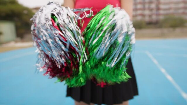 Green And Red Pompoms Waved By A Cheerleader Girl