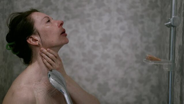 The bathroom becomes a refuge from the noise of the world, where a middle-aged woman enjoys a pleasant shower procedure, forgetting about the fuss and worries.