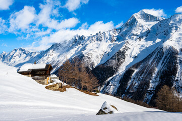 Traditional alpine wooden house in winter mountain snow landscape, Loetschental valley, Switzerland
